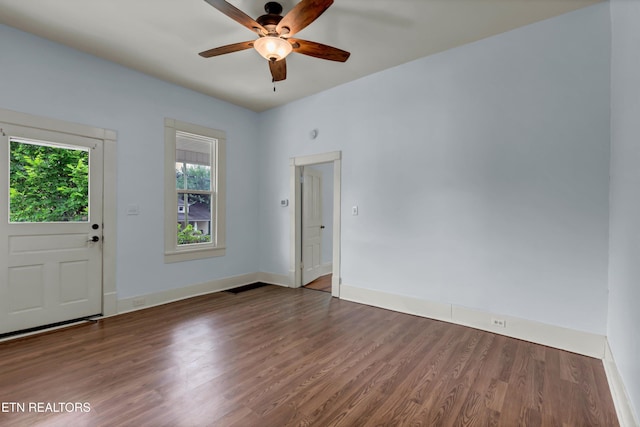 unfurnished room with ceiling fan and dark wood-type flooring