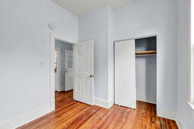 unfurnished bedroom featuring a closet and hardwood / wood-style floors