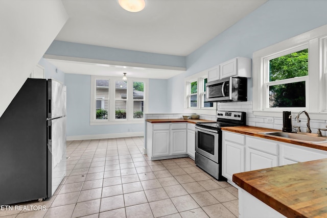 kitchen with white cabinets, sink, appliances with stainless steel finishes, and wood counters