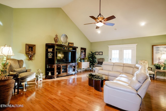 living room featuring hardwood / wood-style flooring, ceiling fan, and high vaulted ceiling