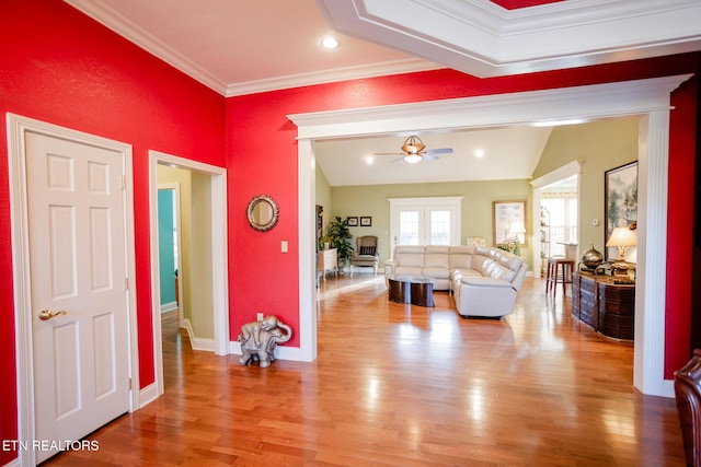 interior space with wood-type flooring, lofted ceiling, ornamental molding, and ceiling fan