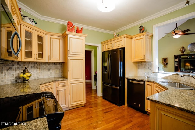 kitchen featuring sink, crown molding, light stone counters, hardwood / wood-style flooring, and black appliances