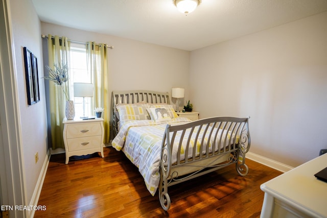 bedroom with dark hardwood / wood-style flooring