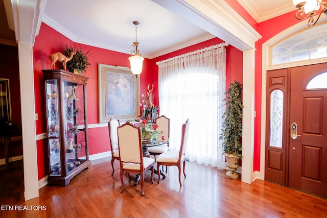 dining space featuring ornamental molding, a healthy amount of sunlight, and hardwood / wood-style floors