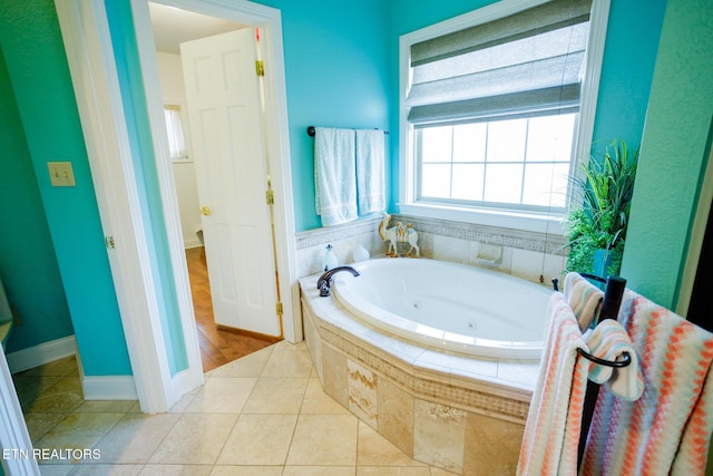 bathroom with tiled bath and tile patterned flooring