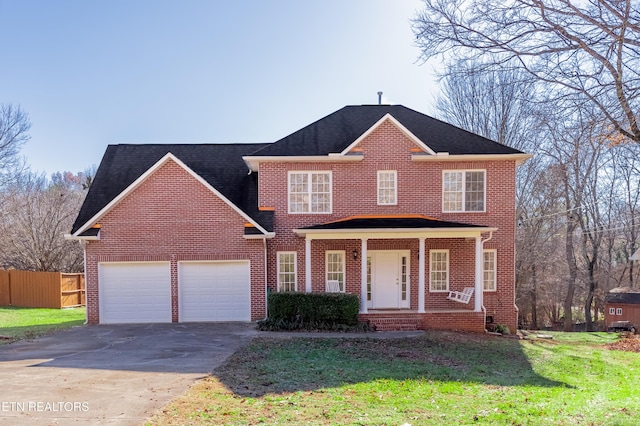 view of front facade with a porch, a garage, and a front lawn