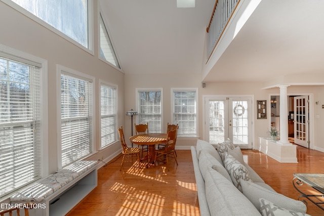 sunroom featuring a healthy amount of sunlight, french doors, and decorative columns