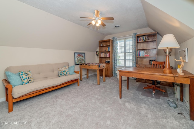 carpeted office featuring a textured ceiling, vaulted ceiling, and ceiling fan