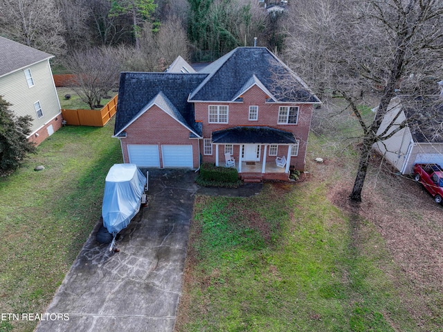 view of front of house with a porch, a garage, and a front lawn