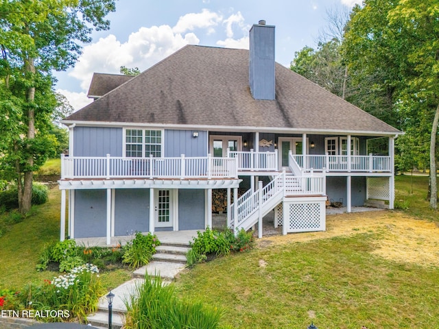 rear view of house featuring covered porch, a yard, and french doors