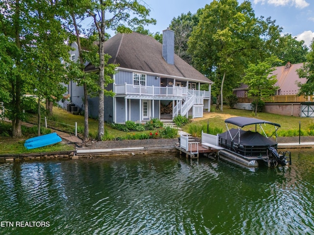 rear view of property with a yard and a water view