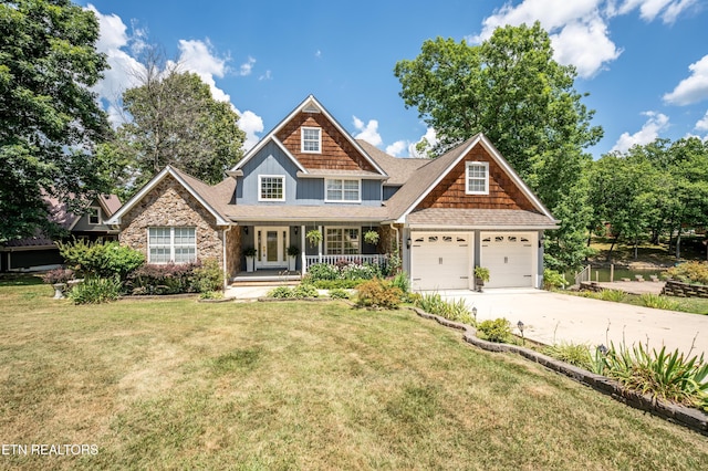 craftsman-style home with a garage, covered porch, and a front yard