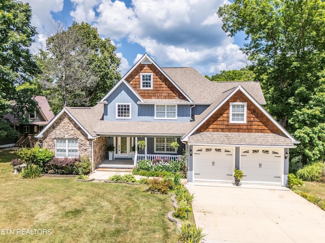 craftsman-style home with a front yard, a porch, and a garage