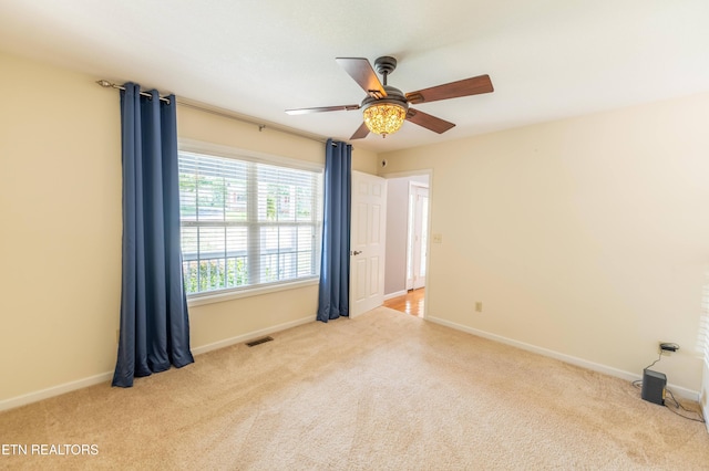 carpeted spare room with ceiling fan