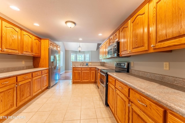 kitchen with appliances with stainless steel finishes, sink, pendant lighting, an inviting chandelier, and lofted ceiling