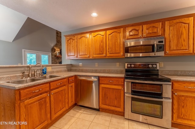 kitchen featuring lofted ceiling, sink, light tile patterned floors, and stainless steel appliances