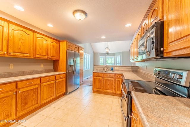 kitchen with pendant lighting, lofted ceiling, sink, light tile patterned floors, and stainless steel appliances