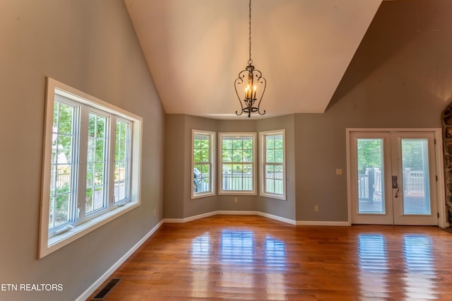 interior space with light hardwood / wood-style flooring, high vaulted ceiling, french doors, and a notable chandelier