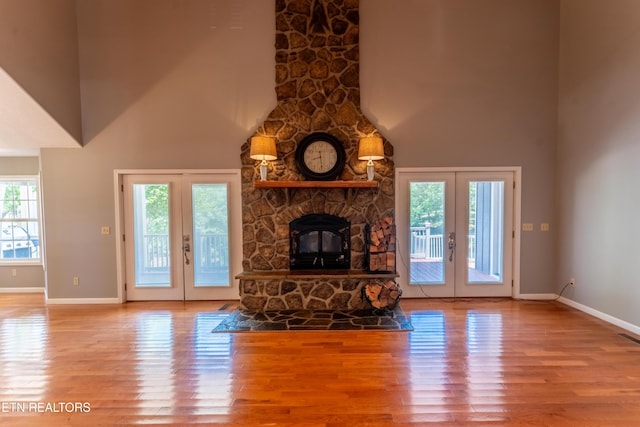 unfurnished living room featuring french doors, hardwood / wood-style flooring, and a high ceiling