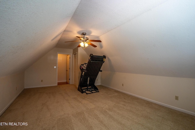 additional living space with ceiling fan, light colored carpet, a textured ceiling, and vaulted ceiling