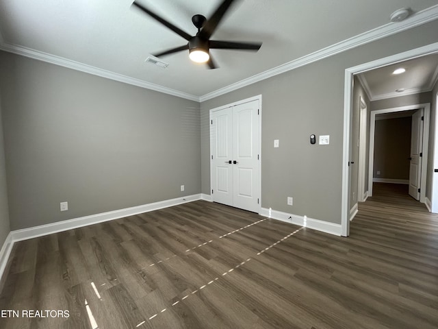 unfurnished bedroom featuring dark hardwood / wood-style flooring, ceiling fan, a closet, and ornamental molding