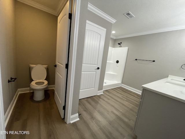 bathroom featuring hardwood / wood-style flooring, toilet, walk in shower, and ornamental molding