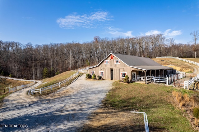 view of front of house with a rural view and an outdoor structure