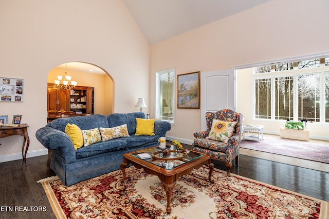 living room featuring dark hardwood / wood-style floors, high vaulted ceiling, and a notable chandelier