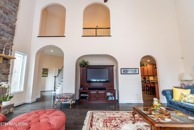 living room with dark hardwood / wood-style floors and a high ceiling