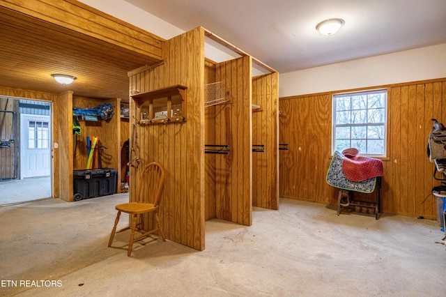 hall featuring concrete flooring and wood walls