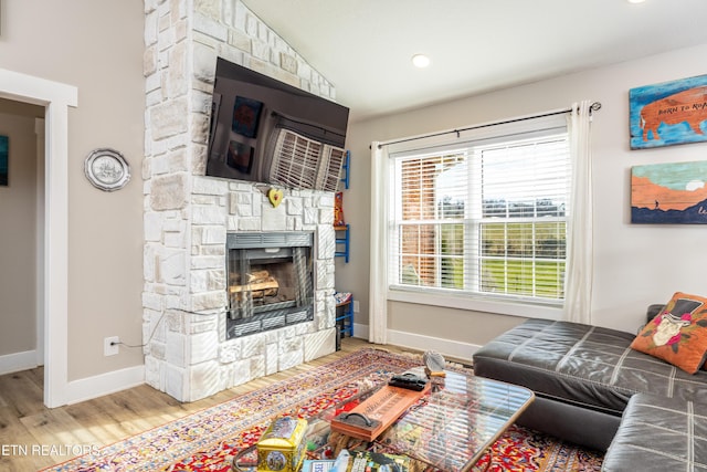 living room featuring wood-type flooring, a fireplace, and vaulted ceiling