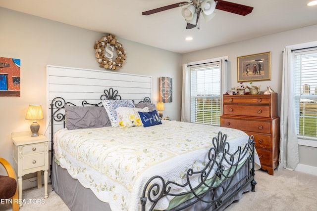 bedroom with ceiling fan and light carpet