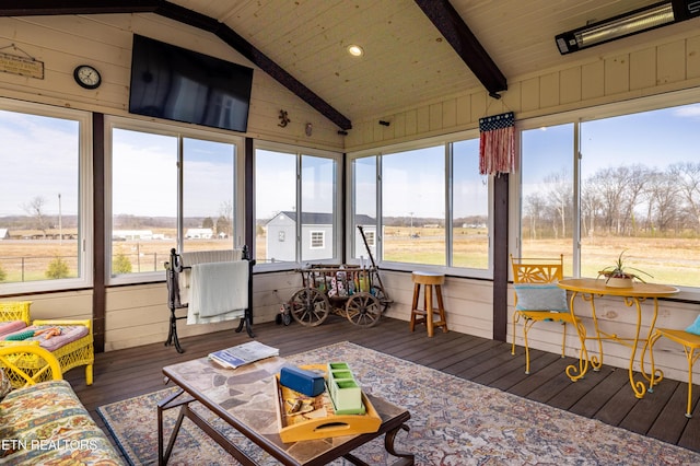 sunroom / solarium featuring lofted ceiling with beams, a rural view, a wealth of natural light, and wooden ceiling