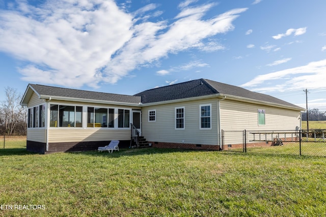 rear view of house with a lawn and a sunroom