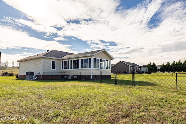 rear view of property featuring a lawn, a sunroom, and cooling unit