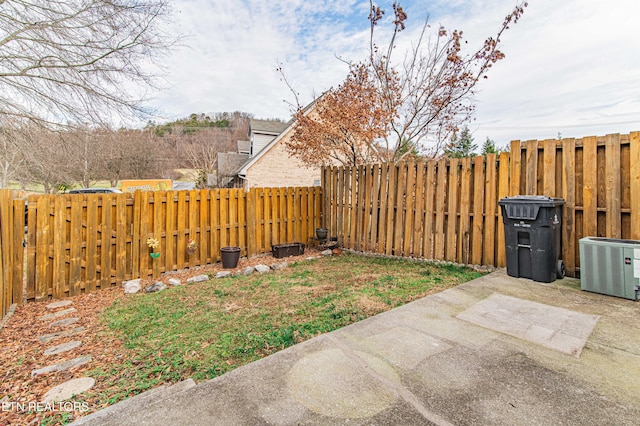 view of yard with central AC unit and a patio area