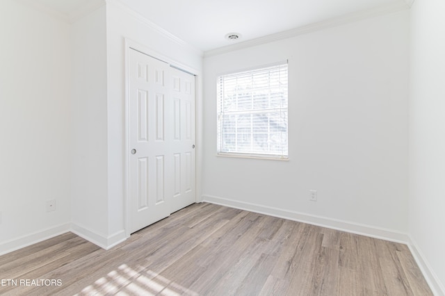 unfurnished bedroom with a closet, light hardwood / wood-style flooring, and ornamental molding