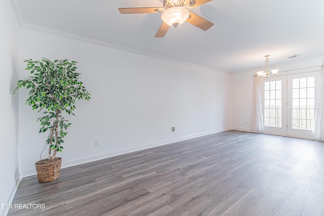 empty room with ceiling fan with notable chandelier, dark hardwood / wood-style floors, and ornamental molding