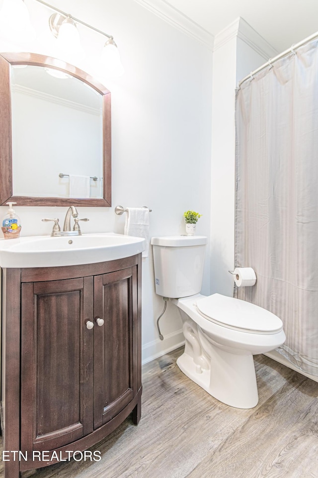 bathroom featuring vanity, toilet, wood-type flooring, and crown molding