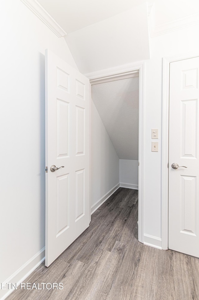 bonus room with hardwood / wood-style flooring and vaulted ceiling