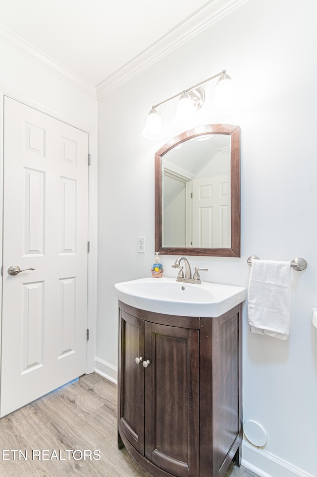 bathroom featuring vanity, hardwood / wood-style flooring, and ornamental molding