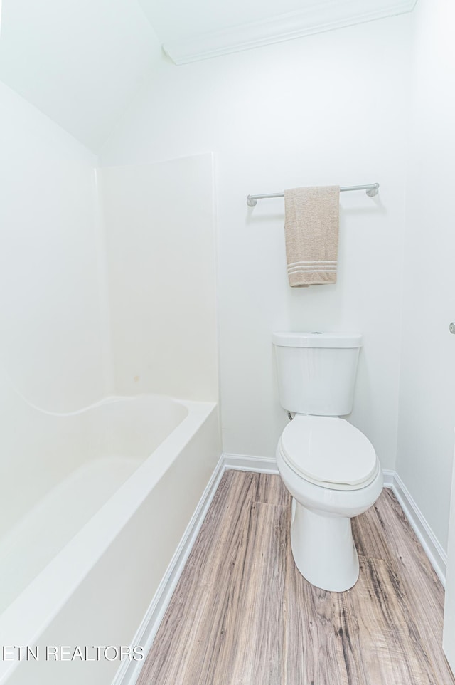 bathroom featuring a washtub, wood-type flooring, and toilet