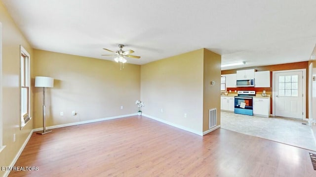 unfurnished living room featuring light hardwood / wood-style flooring and ceiling fan