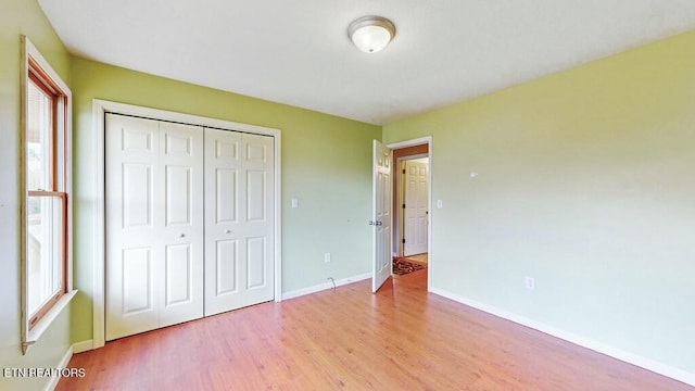 unfurnished bedroom featuring a closet and light wood-type flooring