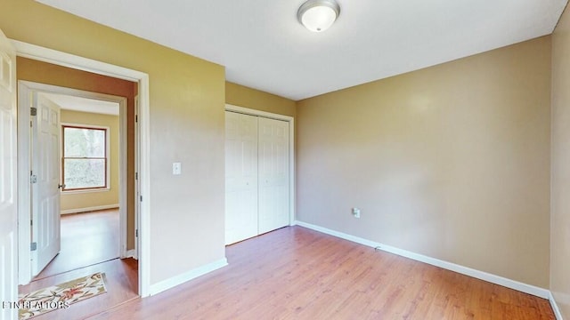 unfurnished bedroom featuring light hardwood / wood-style flooring and a closet