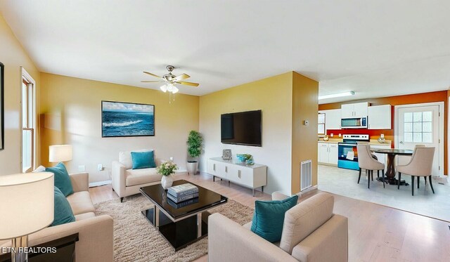 living room with ceiling fan and light hardwood / wood-style flooring