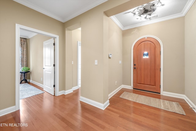 foyer with crown molding and hardwood / wood-style flooring