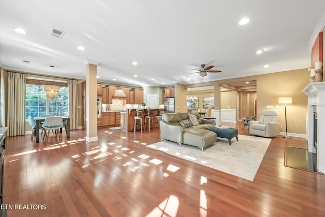 living room with crown molding and light hardwood / wood-style floors