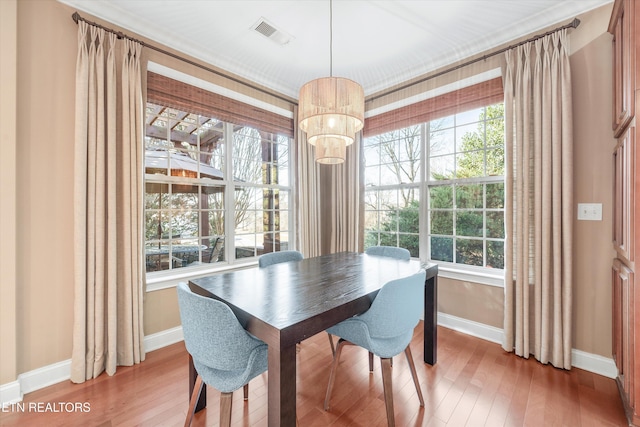 dining room with hardwood / wood-style floors and a notable chandelier