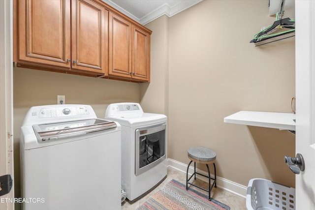 laundry room with cabinets, ornamental molding, light tile patterned floors, and washing machine and clothes dryer